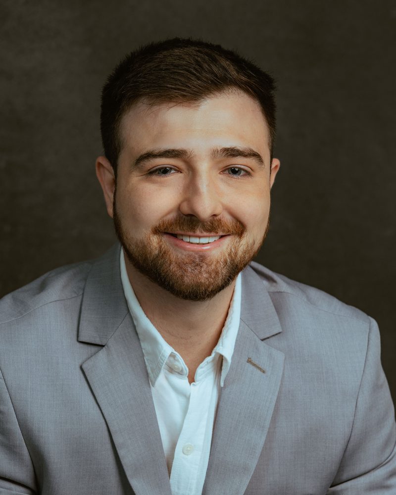 Retrato do Dr. Leonardo Smaniotto de blazer cinza, sorrindo.